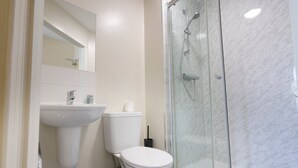 A bathroom with a glass-enclosed shower, a white toilet, and a sink. - Restful Retreat in Cheltenham (Cheltenham)