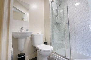 Ein Badezimmer mit Duschkabine, Toilette und Waschbecken.