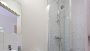 Ein Badezimmer mit Toilette, Waschbecken und einer Duschkabine.