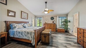 A bedroom with a wooden bed, a chest of drawers, a dresser, and a ceiling fan. - SANCTUARY IN THE SUN, 
great location to go or stay (Mesa)