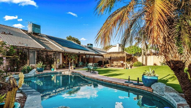 A pool with a curved edge, surrounded by rocks and potted plants. - SANCTUARY IN THE SUN, 
great location to go or stay (Mesa)