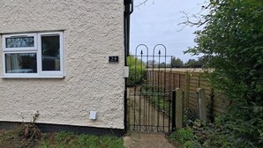 Et hus med hvid facade, et sort metalhegn og et skilt med nummer 24.