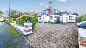 A two-story house with a gravel driveway, a brick wall, and a small garden. - Jeeves Hideaway - sleeps 2 guests  in 1 bedroom (Old Hunstanton)