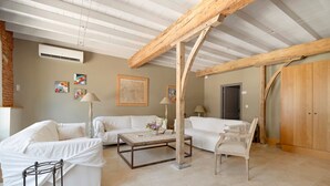 A room with a white sofa, a wooden coffee table, a lamp, and a wooden wardrobe. - Bed and Breakfast 'Chambre 'Cousin Paul'' with Shared Pool, Wi-Fi and Air Conditioning (Verfeil)