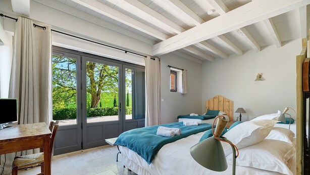 A bedroom with a desk, bed, and a view of greenery outside. - Bed and Breakfast 'Chambre 'Les Bons Enfants'' with Shared Pool, Wi-Fi and Air Conditioning (Verfeil)