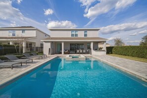 A modern two-story house with a swimming pool, outdoor seating, and a well-maintained garden. - 8BR house sleeps 22 with pool table (Kissimmee)