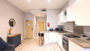 Une cuisine moderne avec des meubles blancs, un four à micro-ondes, un grille-pain et un évier.