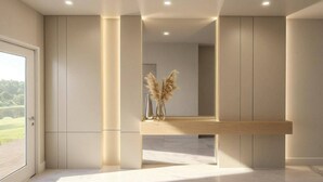 A modern interior with a wooden reception desk, tall columns, and a large mirror reflecting the room. - 9BR house with spa near Disney area (Kissimmee)