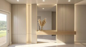 A modern interior with a wooden reception desk, tall columns, and a large mirror reflecting the room. - 9BR house with spa near Disney area (Kissimmee)