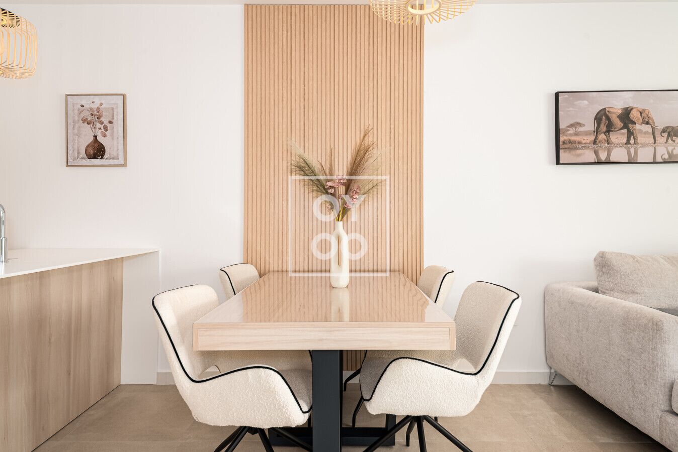 Zona pranzo moderna con tavolo in legno, sei sedie e un vaso con piante essiccate.