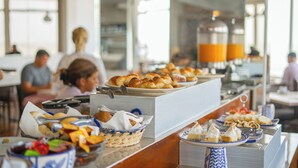 Een buffet met diverse soorten eten en een koffieapparaat op de achtergrond.