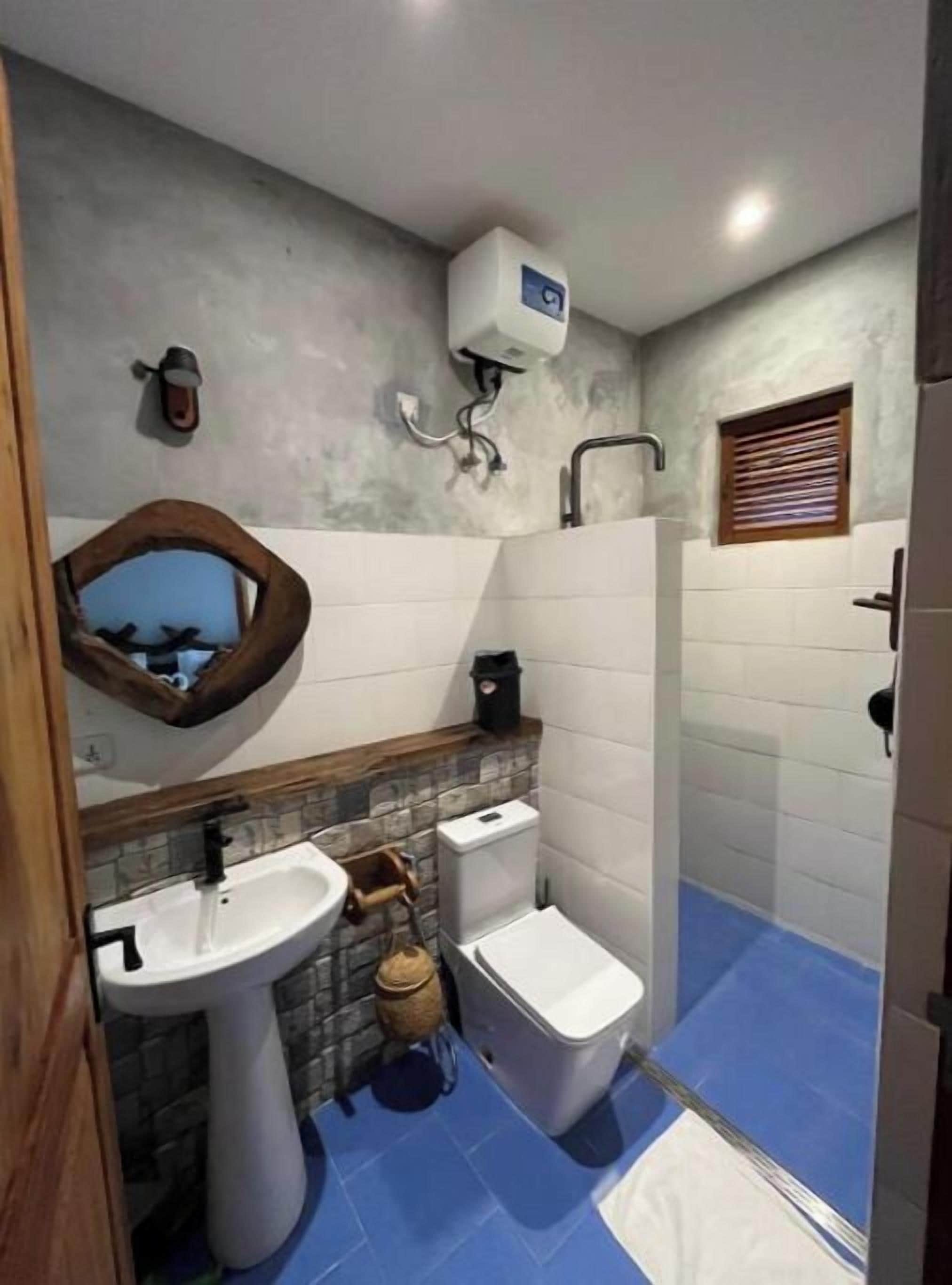 A bathroom with a sink, toilet, and shower area.
