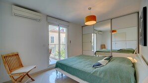 A bedroom with a bed, a chair, a window, and a mirror. - Moderne 2 Pieces Climatise Avec Terrasse A1b230 (Cannes)
