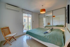A bedroom with a bed, a chair, a window, and a mirror. - Moderne 2 Pieces Climatise Avec Terrasse A1b230 (Cannes)