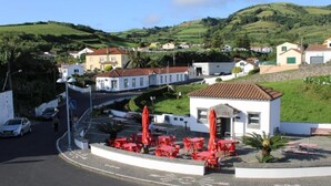 Un piccolo edificio con un cartello che riporta la scritta "CINQ" e un ombrello rosso.