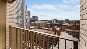 Un immeuble de grande hauteur offrant une vue sur le paysage urbain, avec de nombreux bâtiments et un ciel dégagé.