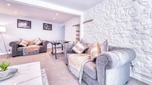 Ein Wohnzimmer mit zwei Sofas, einem Couchtisch und einer Steinwand.