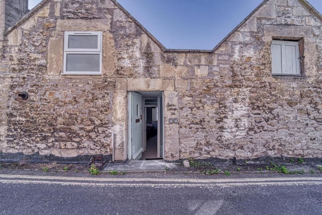 A stone building with a small door and two windows.