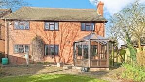 A two-story brick house with a conservatory and a well-maintained lawn. - Large 6 Bedroom Cambridge Abode (Cambridge)