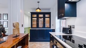 Una cocina moderna con gabinetes azul oscuro, una encimera negra y una estufa integrada.