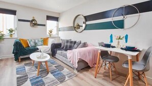 Een moderne woonkamer met een bank, salontafel en eettafel.