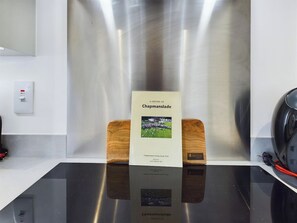Een boek met de titel 'A History of Chapmanslade' op een reflecterend oppervlak met een achtergrond van roestvrij staal.