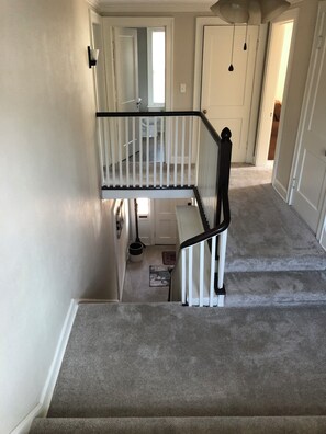 Eine Treppe mit schwarzer Geländer zu einer Zwischenebene.
