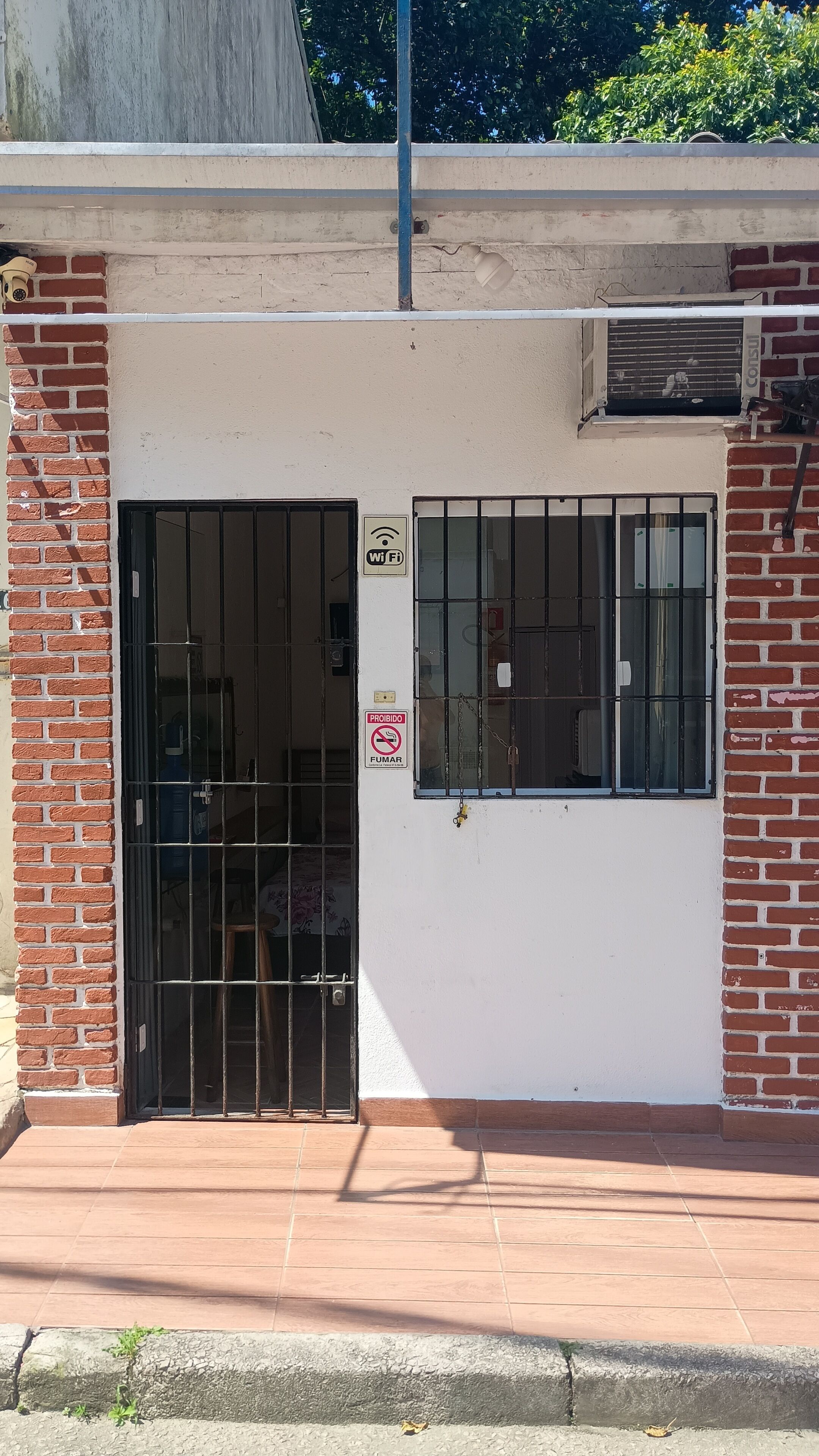 A gated entrance with a Wi-Fi symbol, a no-smoking sign, and a barred window.