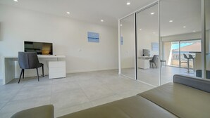 A modern, well-lit room with a large desk, a comfortable chair, a sofa, and a glass partition. - Studio Moderne ET Renove A 2MN Croisette A0b166 (Cannes)