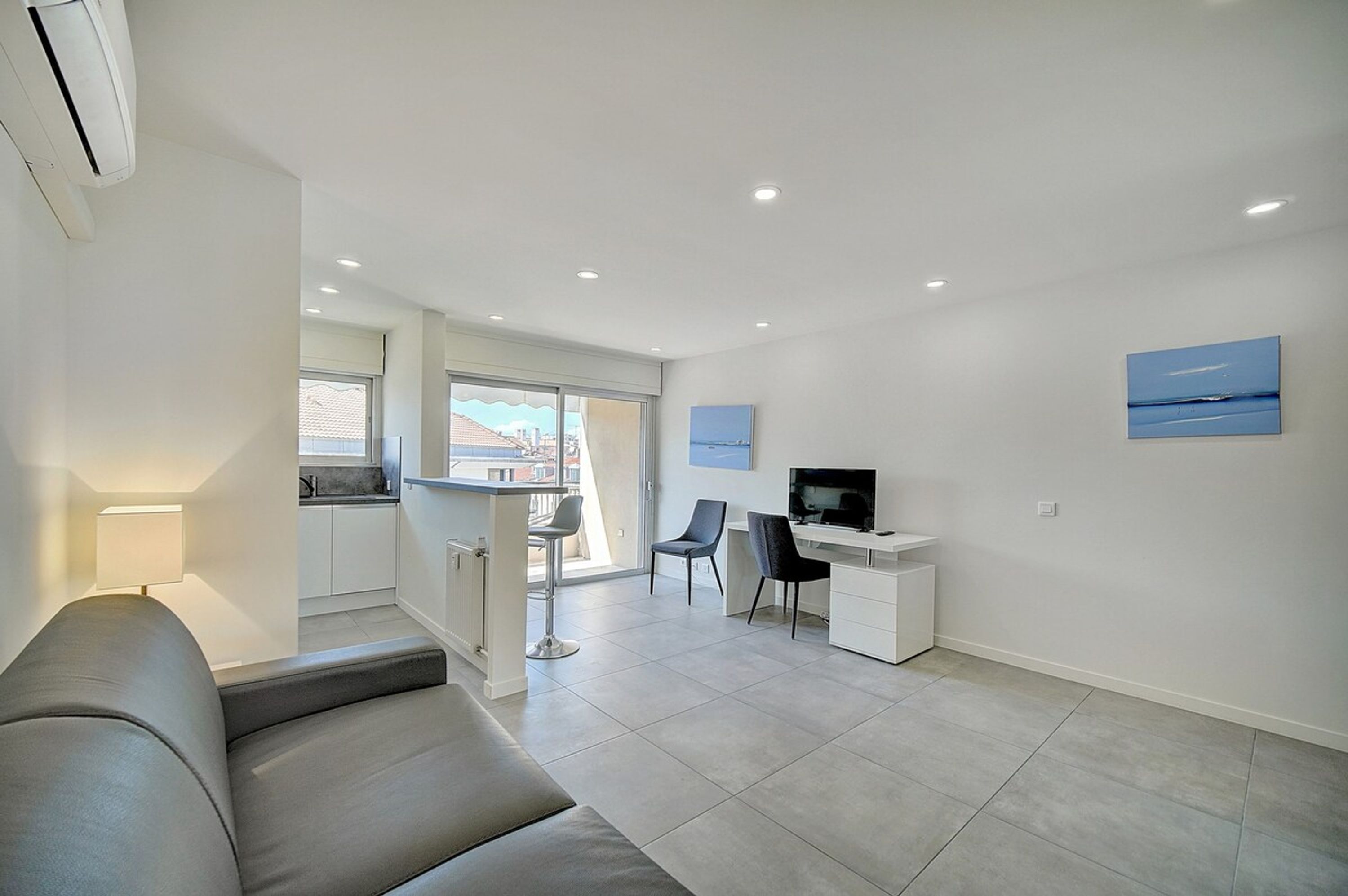 Um apartamento moderno com sala de estar, cozinha compacta e espaço para refeições.