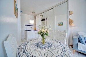 A dining area with a round table, a vase of flowers, and a white chair. - Ref 349442 in Cannes (Cannes)