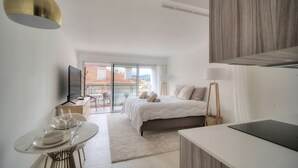 Une chambre à coucher moderne avec un lit, une table de chevet et un téléviseur.