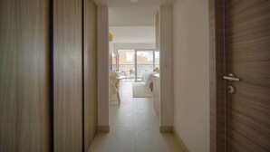 Un couloir menant à une chambre à coucher équipée d’un lit, d’un bureau et d’une chaise.