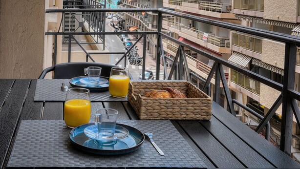 A balcony with a breakfast setup including plates, glasses, and a basket of croissants. - 3 Pieces Moderne Proche Martinez ET Plages A2b249 (Cannes)