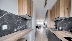 A modern kitchen with wooden cabinets, marble countertops, and a central island. - 3 Pieces Moderne Proche Martinez ET Plages A2b249 (Cannes)