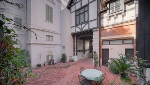 A courtyard with a brick floor, a round table with chairs, and potted plants. - 2 Pieces Charmant Proche Plages DU Midi A1b266 (Cannes)