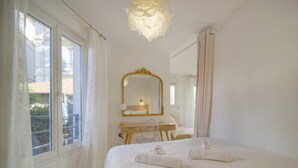 A hotel room with a bed, a desk, a mirror, and a view of the outside. - Superbe Studio Terrasse Parking A0b200 (Cannes)