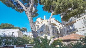 A building with a curved facade, multiple balconies, and a tiled roof. - Superbe Studio Terrasse Parking A0b200 (Cannes)