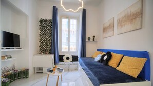 A modern living room with a sofa, a TV, a small table, and a window with curtains. - Charmant Studio Hypercentre A0b211 (Cannes)