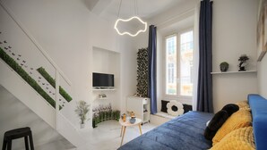 A modern bedroom with a bed, a TV, a staircase, and a window with curtains. - Charmant Studio Hypercentre A0b211 (Cannes)