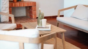 Un coin salon accueillant avec une table en bois, un canapé blanc et une cheminée en briques.