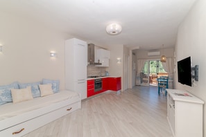 A modern apartment with a kitchen, dining area, and a living room with a sofa. - Studio Apartment 'Monolocale La Maddalena' with Mountain View, Wi-Fi and Air Conditioning (La Maddalena)