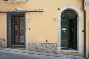 Un edificio con dos puertas numeradas, 38 y 40, y una base de piedra.