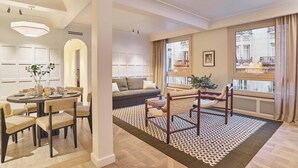 A modern living room with a dining area, large windows, and a view of the city. - Sublim AC Apartment 3 Bdr Saint Germain des Prés (Paris)