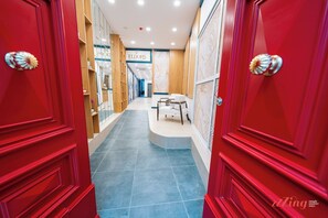 A hotel corridor with red doors, a reception desk, and a sign for 'Eldor's Boutique Hotel'. - El Doris Boutique Living St Julians  (St. Julian's)