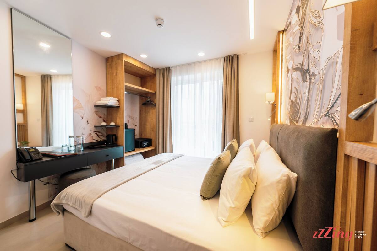 Une chambre d’hôtel moderne, dotée d’un grand lit, d’un bureau et d’une armoire.