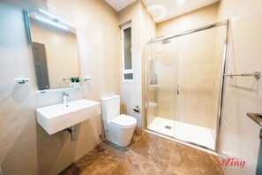 A modern bathroom with a white sink, toilet, and glass shower enclosure. - El Doris Boutique Living St Julians  (St. Julian's)