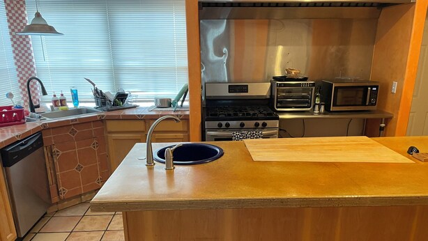 A kitchen with a central island, a sink, a stove, and a microwave. - DOWNTOWN PHX PRIVATE BEDROOM SHARED BATHROOM KITCHEN COMMON AREAS SWIMMING POOL (Phoenix)