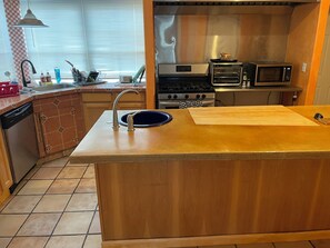 A kitchen with a central island, a sink, a stove, and a microwave. - DOWNTOWN PHX PRIVATE BEDROOM SHARED BATHROOM KITCHEN COMMON AREAS SWIMMING POOL (Phoenix)