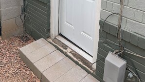 A white front door with a glass panel, a metal doorbell, and a small step leading to the door. - DOWNTOWN PHX PRIVATE BEDROOM SHARED BATHROOM KITCHEN COMMON AREAS SWIMMING POOL (Phoenix)